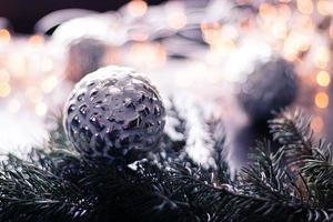 giocattoli di natale, palline d'argento sul ramo dell'albero di natale. sfondo bokeh decorazione natalizia. copia spazio foto