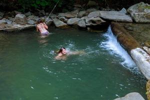 bella ragazza con sua figlia che nuota nel fiume foto