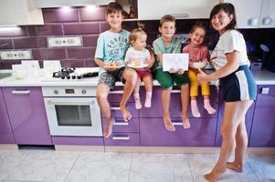 madre con bambini che cucinano in cucina, momenti felici per bambini. foto