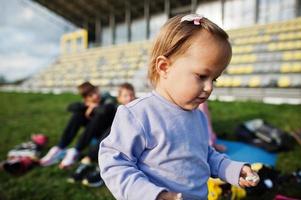 bambina primo piano ritratto. la famiglia sportiva trascorre il tempo libero all'aria aperta con scooter e pattini. foto