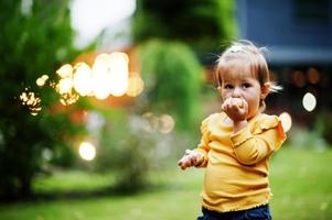 bambina con ciambelle al cortile serale. gustoso cibo per ciambelle. foto