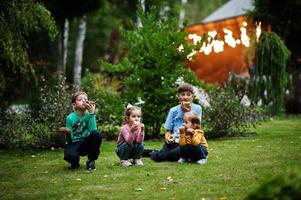 quattro bambini con ciambelle al cortile serale. gustoso cibo per ciambelle. foto