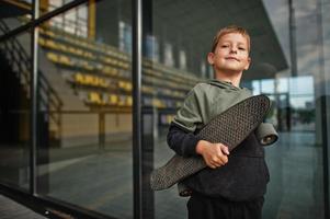 ragazzo con penny board in mano allo stadio. foto