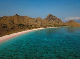 veduta aerea della bellissima spiaggia rosa sull'isola di flores con nuvole di montagna e cielo foto