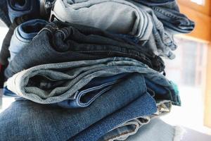 vestiti alla moda. mucchio di jeans. foto ravvicinata di pantaloni di jeans in pile