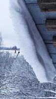 Pericolo. la neve pende dal tetto. frana di neve. foto