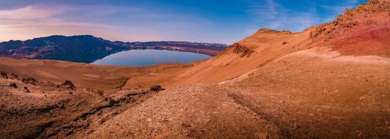 vista panoramica sul paesaggio islandese della grande caldera vulcanica askja, nel mezzo del deserto vulcanico negli altopiani, con terreno vulcanico rosso, turchese e arancione ai colori del tramonto, islanda. foto