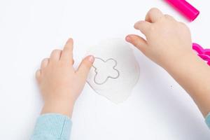 le mani dei bambini giocano la pasta per la creatività dei bambini. gioco da tavolo per lo sviluppo della motricità fine foto