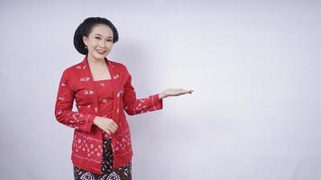 bellezza asiatica in kebaya che punta il lato vuoto isolato su sfondo bianco foto