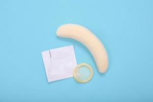 educazione sessuale con banana e preservativo isolati su sfondo blu foto