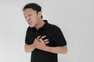 attacco di cuore o cuore spezzato di un giovane asiatico con emozione ferita indossa una camicia nera foto