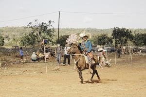 un cavaliere uomo con cappello tradizionale tilangga a cavallo pronto a correre la cultura dall'isola di rote, nusa tenggara orientale, indonesia. rote, indonesia - 23 marzo 2020 foto