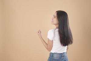 un ritratto di donna asiatica con t-shirt bianca su sfondo marrone chiaro studio foto