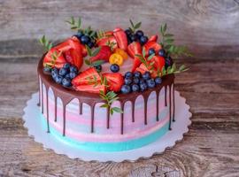 bella torta fatta in casa con glassa di crema di formaggio rosa e turchese foto