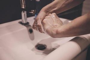 uomo che si lava le mani con sapone foto