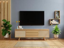 sfondo della parete di colore blu scuro, arredamento moderno del soggiorno con tv e armadietto. foto