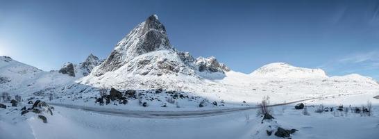 panorama della catena montuosa innevata con cielo blu e autostrada nel nordland foto