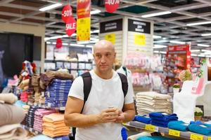 un uomo durante una vendita sceglie gli asciugamani foto
