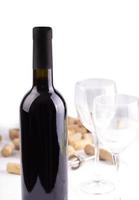 i bicchieri da vino rosso, la bottiglia e i tappi di sughero. isolato su sfondo bianco foto