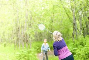 la donna con il bambino che gioca a badminton nel bosco foto