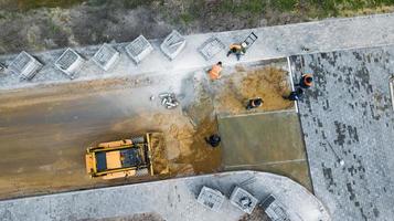 i lavoratori posano le piastrelle per pavimentazione vista dall'alto da un drone foto