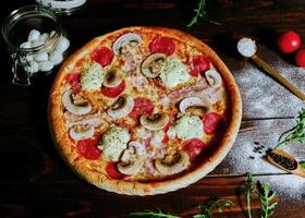 appetitosa pizza con funghi su un vassoio di legno foto