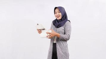 felice asiatico giovane donna che apre il contenuto della borsa isolato su sfondo bianco foto