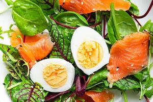 insalata salmone salato, uova, lattuga verde porzione fresca pasto sano dieta pescataria foto