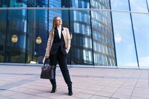 donna d'affari felice di successo con la borsa su sfondo edificio per uffici foto