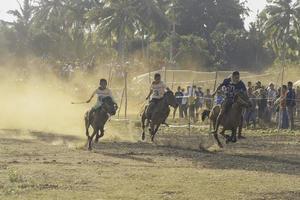 giovani fantini in corridori di cavalli alla cultura tradizionale della corsa di cavalli di hus dall'isola di rote, nusa tenggara orientale, indonesia. rote, indonesia - 27 marzo 2020 foto