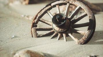 grande ruota di legno nella sabbia foto