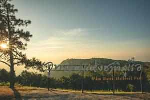 provincia di loei, tailandia dicembre 2021 cartello del parco nazionale di phu ruea con sfondo dell'alba mattutina e della bellissima valle al punto di vista in cima al parco nazionale di phu ruea. foto