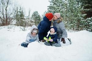 padre e madre con due figlie nella natura invernale. all'aperto nella neve. foto