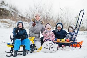 giochi in famiglia e gite in slitta in inverno all'aperto, mamma e bambini si divertono. foto