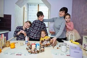 la madre con quattro bambini fa una ghirlanda per la vigilia di Natale e la decorazione artigianale. festa di capodanno. foto