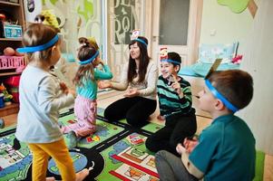 famiglia felice con quattro bambini che giocano a indovinare chi divertendosi a casa. foto