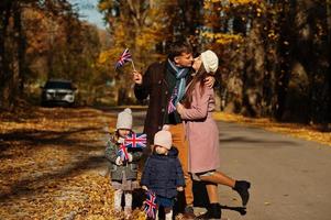 festa nazionale del regno unito. famiglia con bandiere britanniche nel parco autunnale. Britishness che celebra il Regno Unito. due bambini. foto