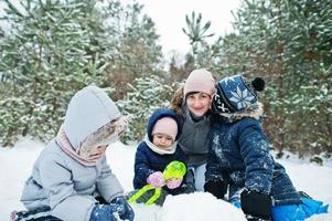 madre con tre figli nella natura invernale. all'aperto nella neve. foto