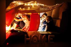 giocare con i bambini in tenda di notte a casa. umore hygge. foto