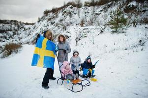 famiglia scandinava con bandiera svedese nel paesaggio svedese invernale. foto