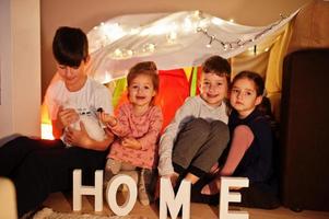 giocare ai bambini con il gattino in tenda di notte a casa. umore hygge. foto