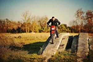 pilota di enduro seduto sulla sua moto foto