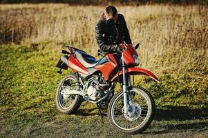 il motociclista resta al tramonto con lui bici da enduro foto