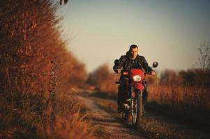 pilota di enduro seduto sulla sua moto foto