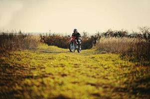 pilota di enduro seduto sulla sua moto foto