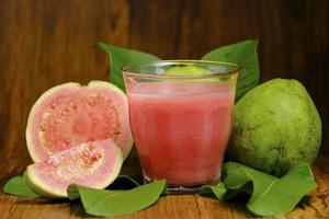 il succo di guava viene servito su uno sfondo di legno foto