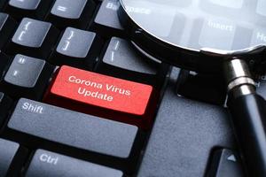 una tastiera nera con pulsante rosso scritto con aggiornamento coronavirus foto