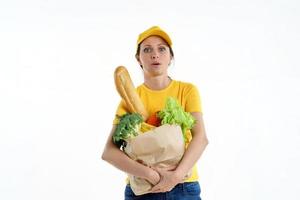 donna di consegna stanca in posa gialla con borsa della spesa, sfondo bianco foto