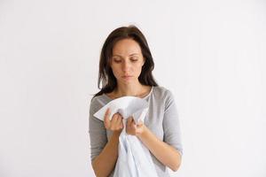 donna che annusa camicia pulita su sfondo chiaro foto