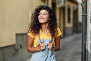 giovane donna nordafricana con acconciatura riccia nera all'aperto. foto